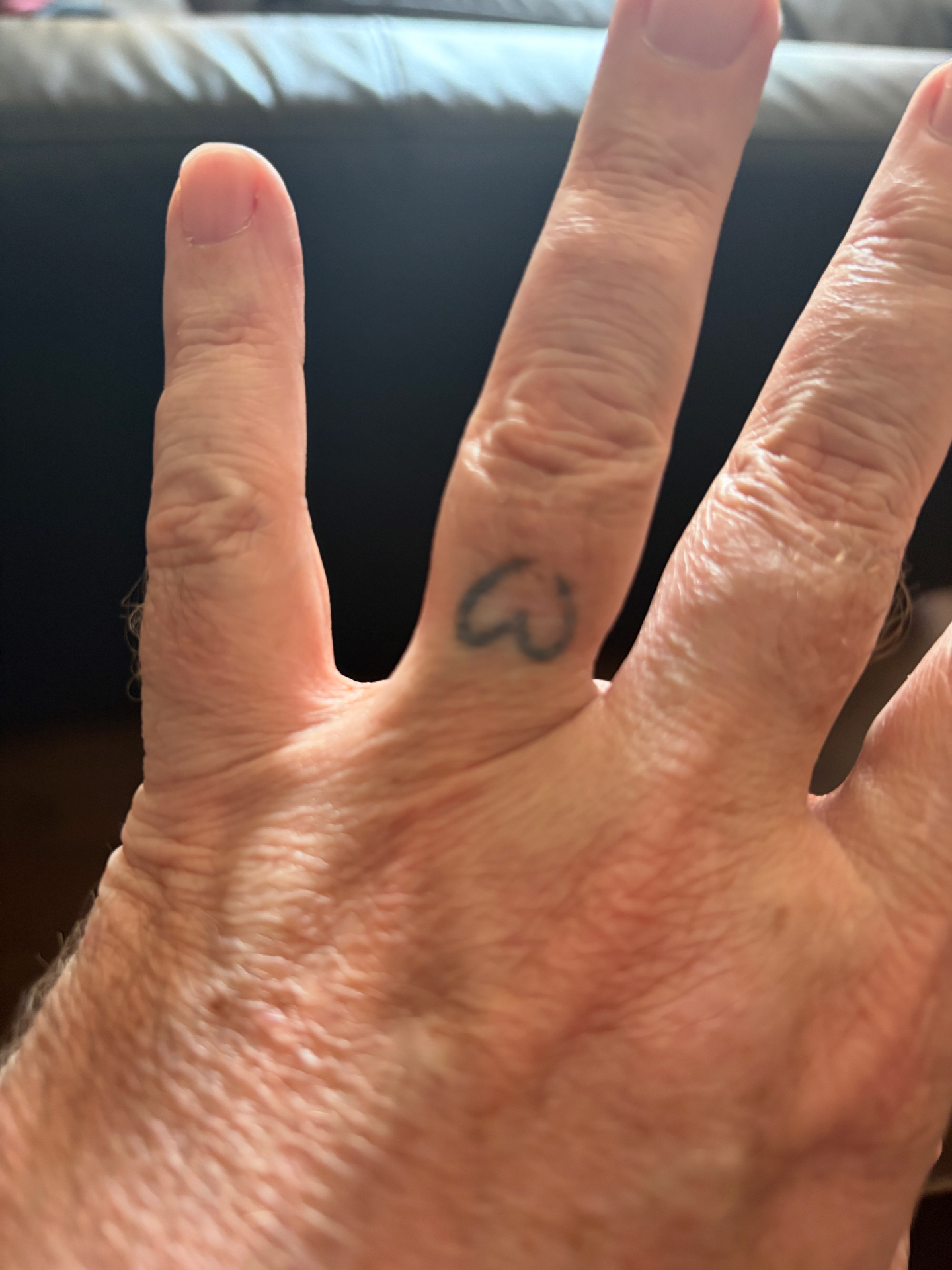 His ring finger — heart tattoo
